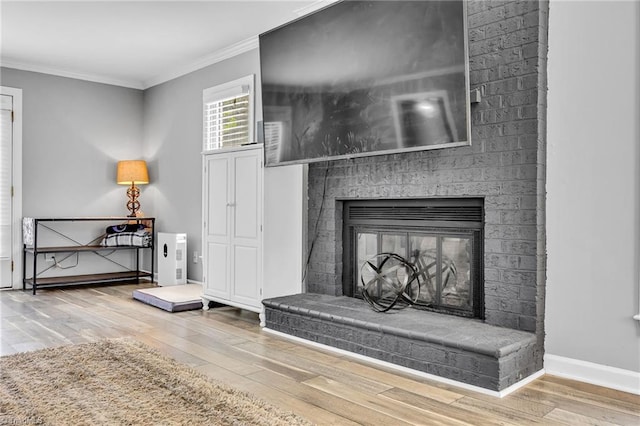 details with ornamental molding, a brick fireplace, and wood-type flooring