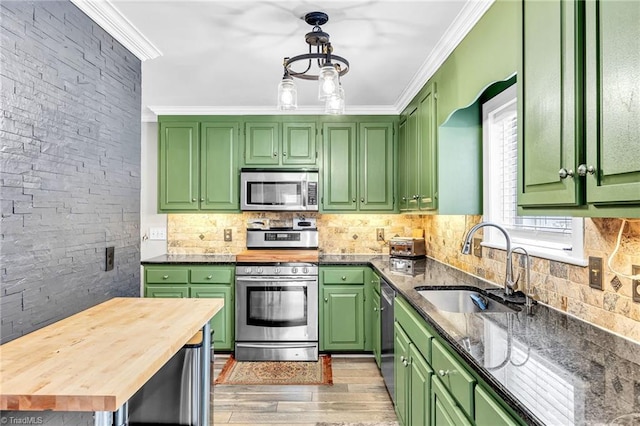 kitchen featuring stainless steel appliances, crown molding, sink, and green cabinets