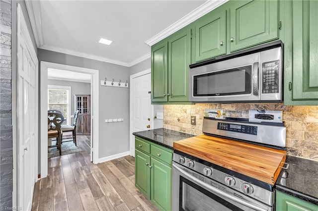 kitchen with ornamental molding, stainless steel appliances, and green cabinets