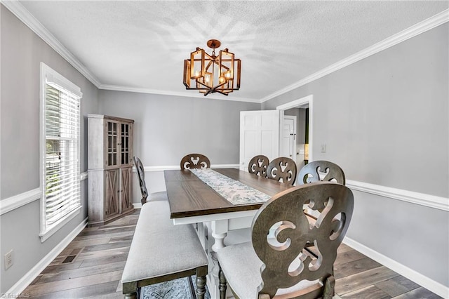 dining room with an inviting chandelier, ornamental molding, dark hardwood / wood-style floors, and a textured ceiling