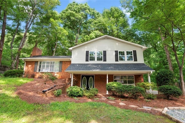 tri-level home featuring brick siding and a porch