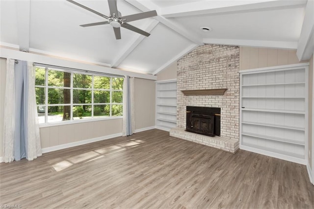 unfurnished living room with wood finished floors, baseboards, ceiling fan, and built in shelves