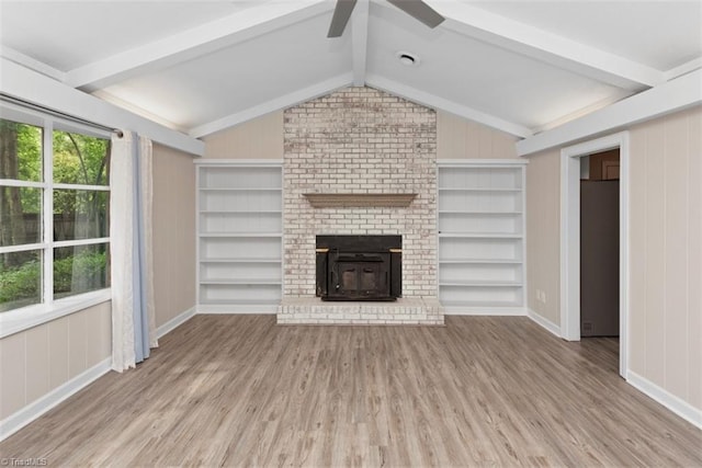 unfurnished living room with ceiling fan, wood finished floors, built in shelves, and baseboards