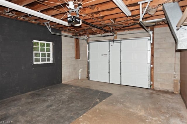 garage featuring a garage door opener and concrete block wall