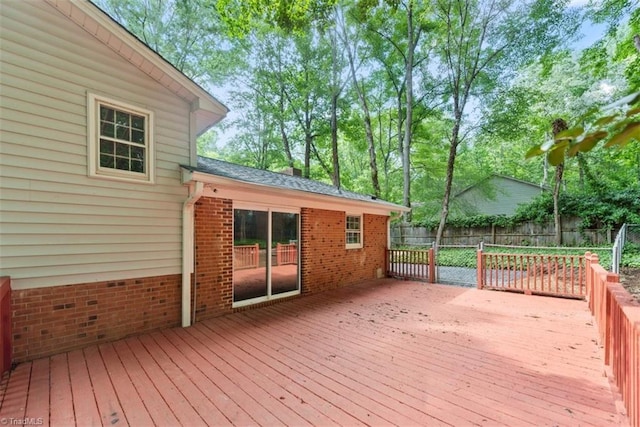 wooden deck with a fenced backyard
