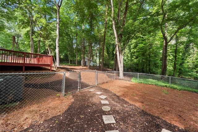 fenced backyard with a wooden deck and a gate