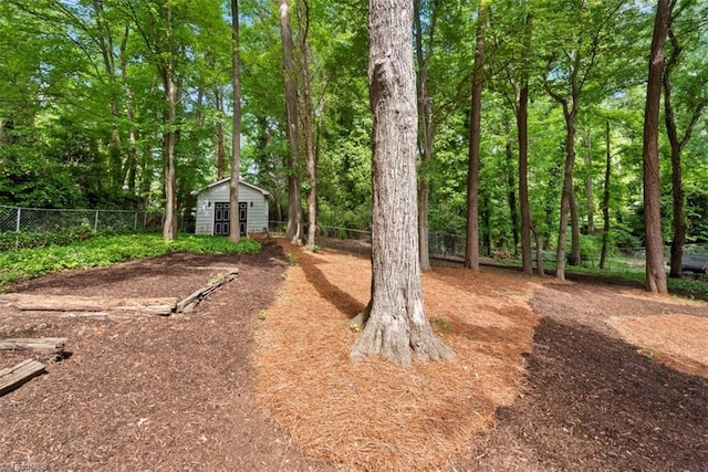 view of yard featuring fence, an outbuilding, and a shed