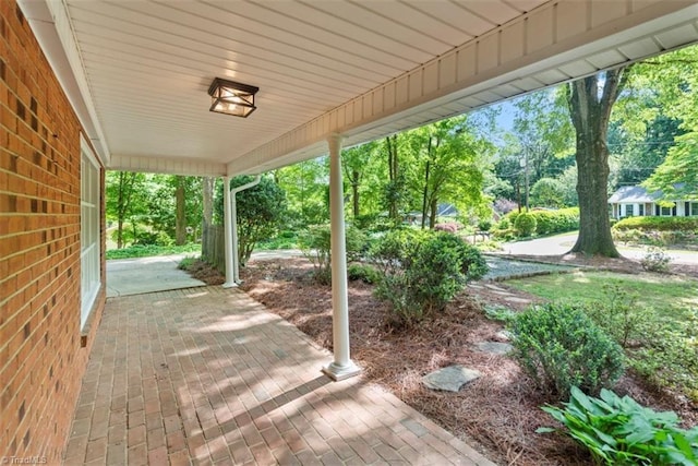 view of patio / terrace featuring view of scattered trees and covered porch