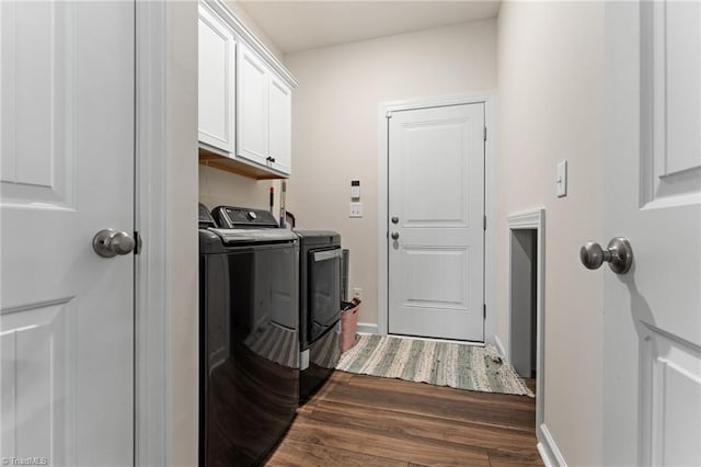 washroom featuring cabinets, washing machine and clothes dryer, and dark hardwood / wood-style floors