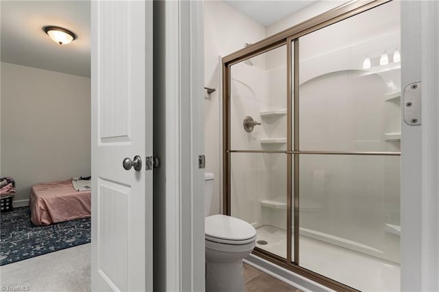 bathroom featuring toilet and a shower with door