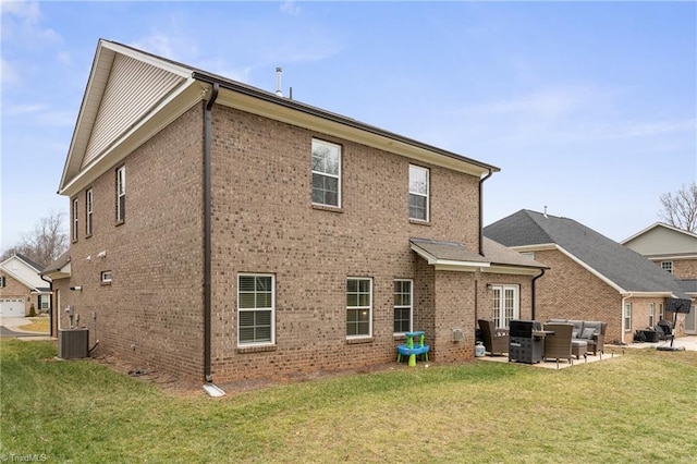 rear view of property featuring a yard, central AC unit, and a patio area