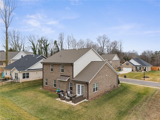 rear view of property with an outdoor living space, a yard, a garage, and a patio