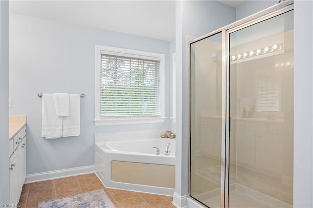 full bath featuring a stall shower, tile patterned flooring, a garden tub, and vanity