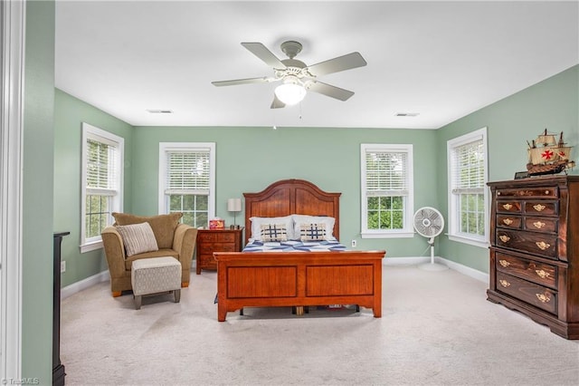 bedroom featuring baseboards, visible vents, a ceiling fan, and light colored carpet