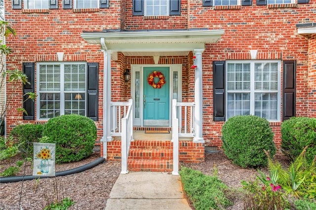 view of exterior entry featuring brick siding