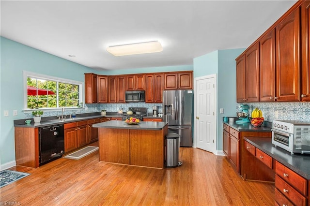 kitchen with stainless steel appliances, a kitchen island, light wood-style floors, backsplash, and dark countertops