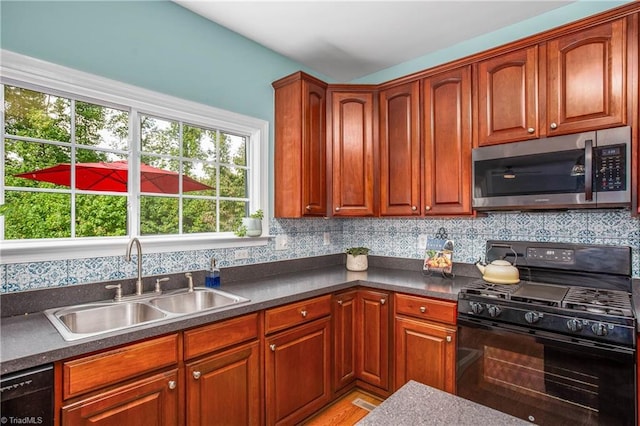 kitchen with decorative backsplash, dark countertops, a sink, and black appliances