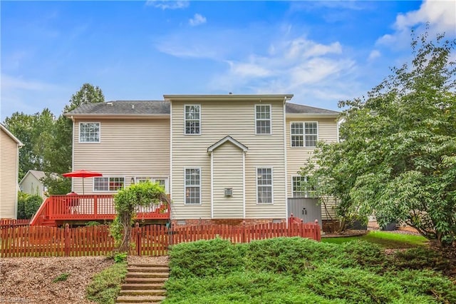 rear view of house featuring fence and a deck