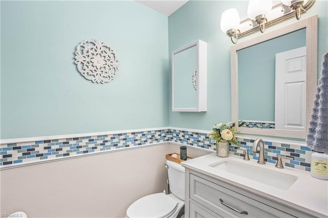 half bathroom with toilet, tile walls, and vanity