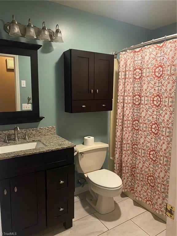 bathroom with walk in shower, vanity, toilet, and tile patterned flooring