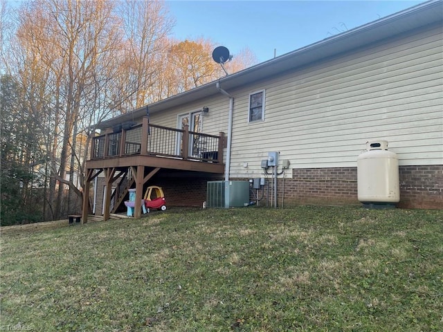 exterior space with a wooden deck, central AC, and a lawn