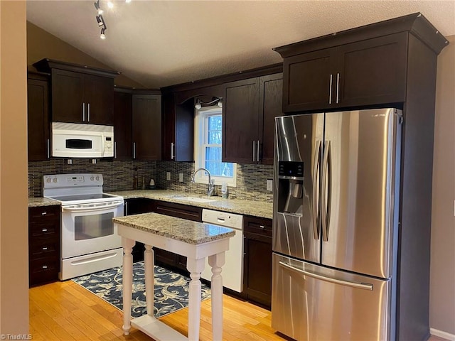 kitchen with light hardwood / wood-style floors, white appliances, light stone countertops, and sink