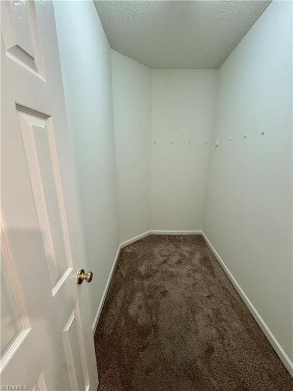 unfurnished room with carpet flooring, a textured ceiling, and baseboards