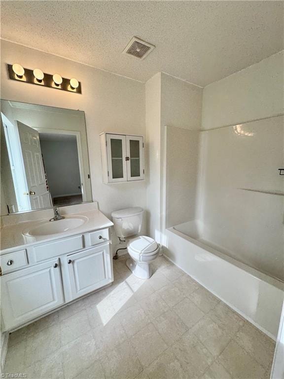bathroom featuring toilet, a textured ceiling, vanity, and shower / tub combination