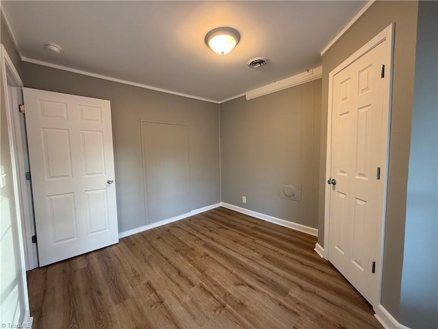 unfurnished bedroom featuring ornamental molding and dark hardwood / wood-style flooring