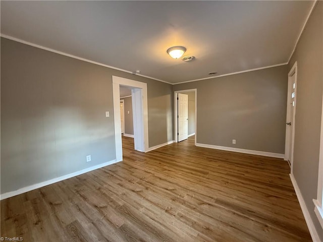 unfurnished room with crown molding and light hardwood / wood-style floors