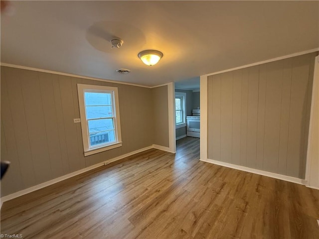 empty room featuring ornamental molding and wood-type flooring