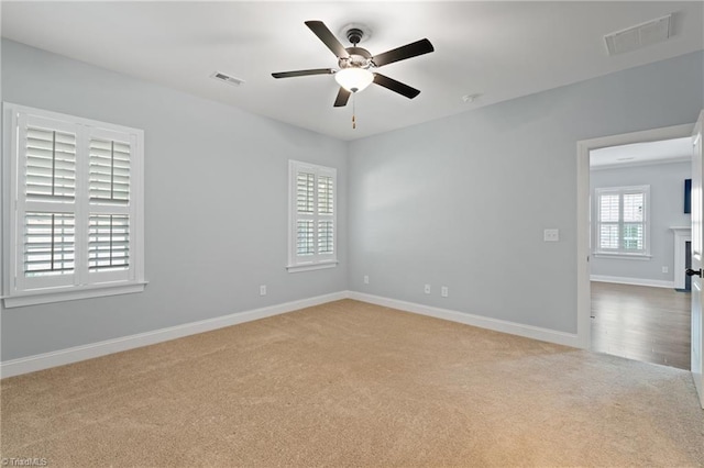 unfurnished room with ceiling fan and light colored carpet