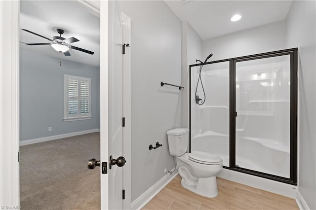 bathroom featuring toilet, hardwood / wood-style flooring, ceiling fan, and a shower with shower door