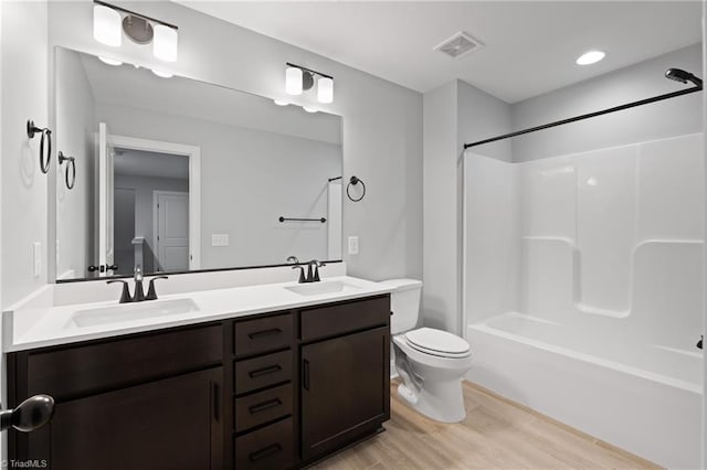 full bathroom featuring toilet, vanity, wood-type flooring, and shower / washtub combination