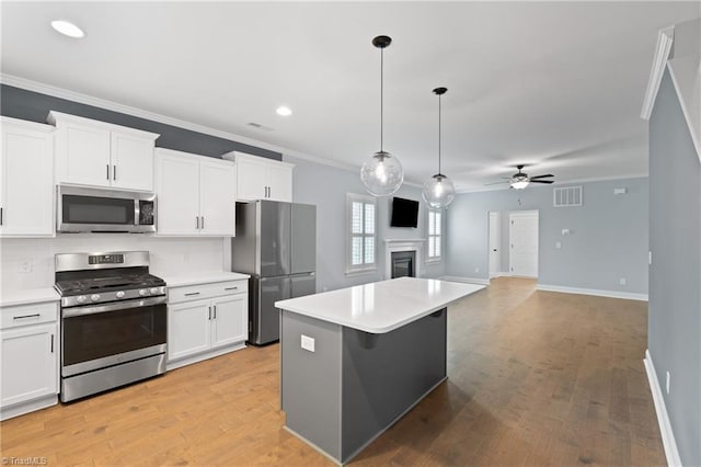 kitchen featuring white cabinets, appliances with stainless steel finishes, and light hardwood / wood-style flooring