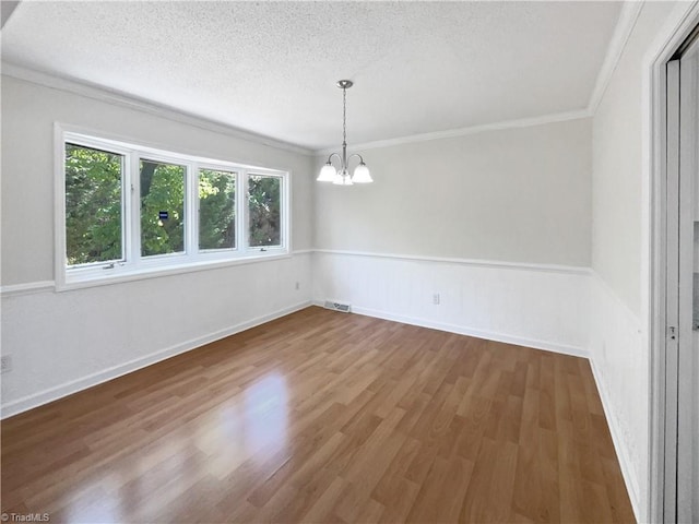 unfurnished dining area with visible vents, wood finished floors, a chandelier, and a wealth of natural light