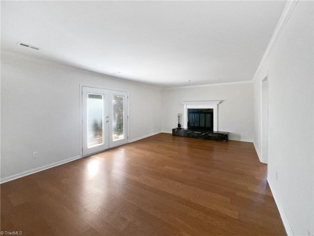 unfurnished living room featuring french doors, visible vents, ornamental molding, and wood finished floors