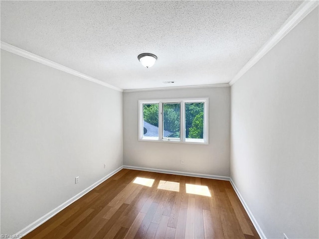 spare room featuring baseboards, ornamental molding, hardwood / wood-style flooring, and a textured ceiling