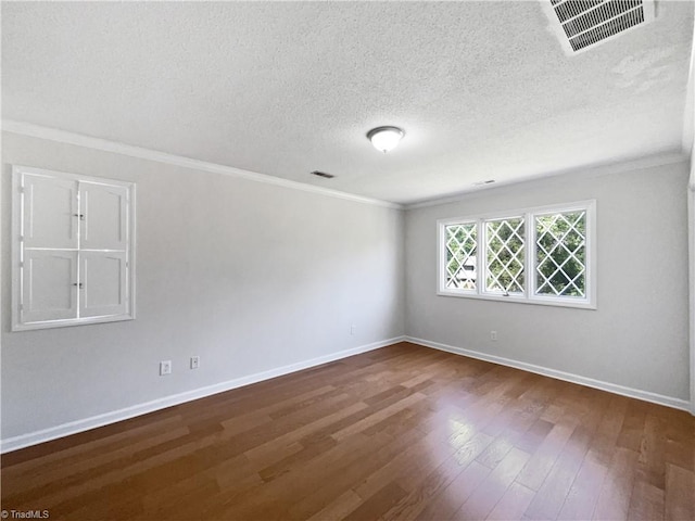 spare room featuring crown molding, dark wood-style floors, and visible vents