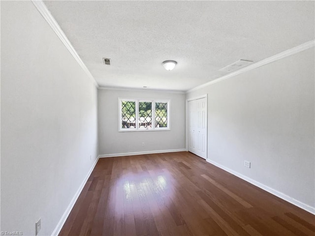 unfurnished room featuring crown molding, a textured ceiling, dark wood-style flooring, and baseboards