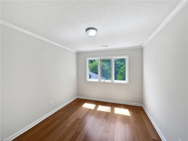 unfurnished room featuring dark wood-type flooring, ornamental molding, a textured ceiling, and baseboards