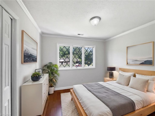 bedroom featuring visible vents, ornamental molding, dark wood finished floors, and baseboards