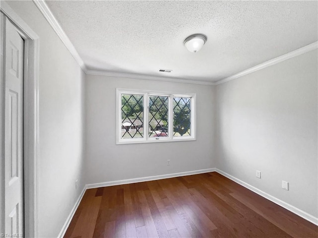 unfurnished room with visible vents, ornamental molding, baseboards, dark wood-type flooring, and a textured ceiling