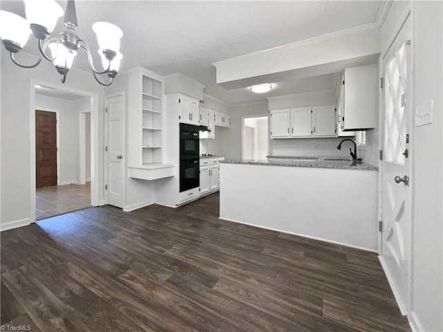 kitchen featuring an inviting chandelier, open shelves, dark wood-style flooring, white cabinetry, and a sink