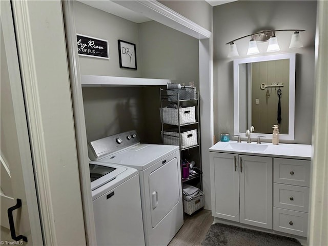 clothes washing area featuring sink, dark hardwood / wood-style floors, and washing machine and clothes dryer