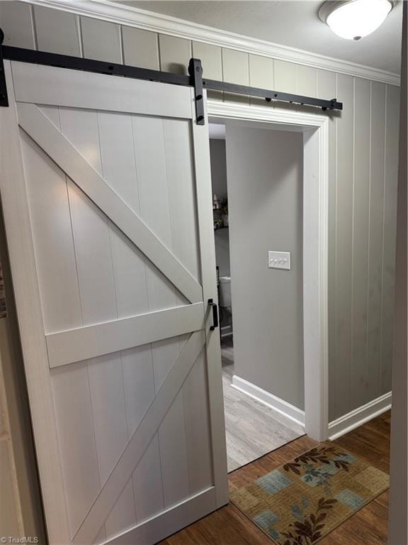 details featuring hardwood / wood-style floors, ornamental molding, and a barn door