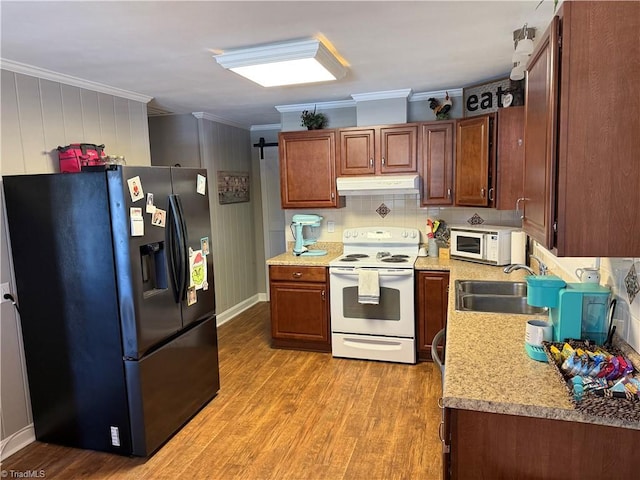 kitchen featuring light wood-type flooring, white appliances, ornamental molding, and sink