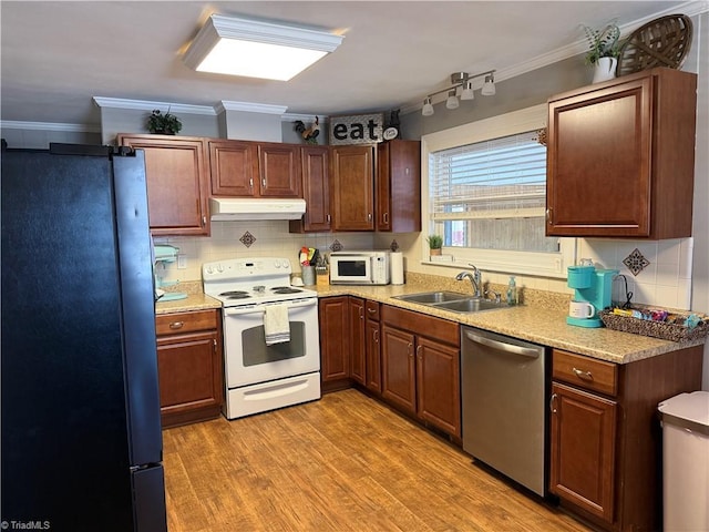 kitchen with sink, white appliances, ornamental molding, and light hardwood / wood-style floors