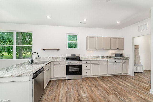 4000 Groometown Rd, Greensboro, NC 27407 - kitchen featuring stainless steel appliances, light wood-type flooring, light stone counters, and recessed lighting