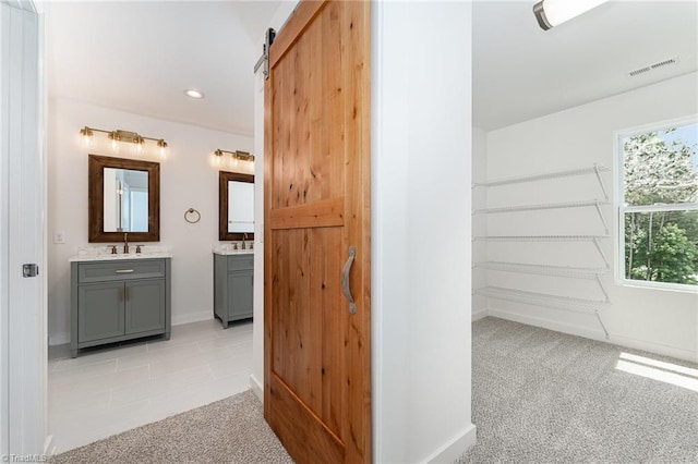 4000 Groometown Rd, Greensboro, NC 27407 - corridor with a barn door, light colored carpet, recessed lighting, and light tile patterned floors